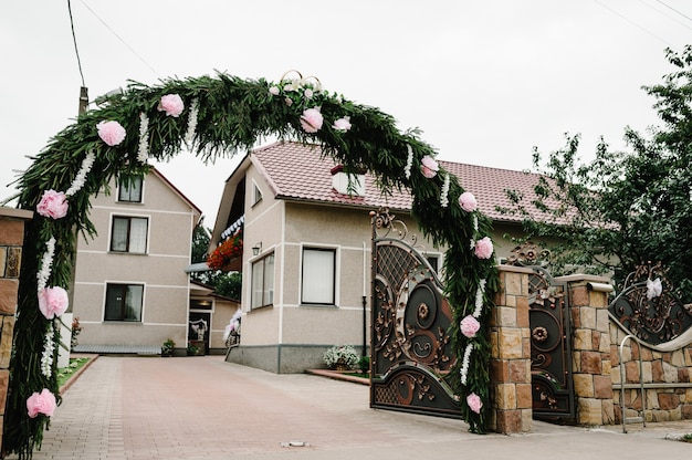 Der verzierte Blumenbogen und das Eingangstor, der Hof mit dem Haus. Morgen Vorbereitungen für einen Hochzeitstag.