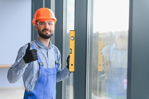 Der Vorarbeiter montiert einen Fensterrahmen im Raum