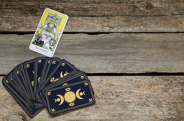 Der Wagen und andere Tarotkarten auf einem flachen Holztisch Platz für Text