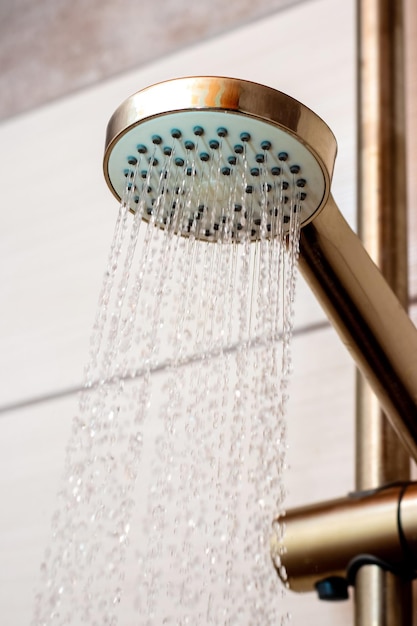 Der Wasserfluss aus der Gießkanne in der Dusche Nahaufnahme Duschen