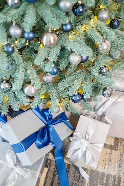 Der Weihnachtsbaum ist geschmückt mit Spielzeug und Girlanden mit Geschenken darunter Weihnachtsgeschenke unter dem Baum