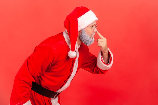 Foto der weihnachtsmann berührt die nase mit dem finger und tadelt den lügner in der täuschung.