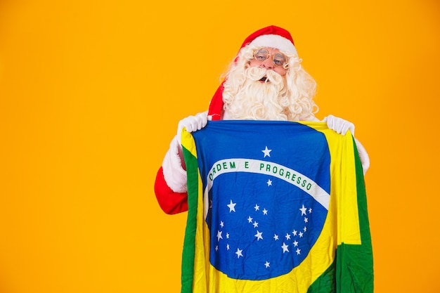 Der Weihnachtsmann ist ein Fan von Brasilien. Weihnachtsmann-Anhänger des brasilianischen Teams. Sportmeisterschaft. Weihnachtsmann, der die brasilianische Flagge hält. Fußballspiel.
