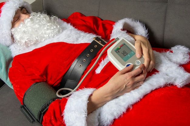 Der Weihnachtsmann ist krank und fühlt sich nicht wohl. Der Weihnachtsmann misst den Blutdruck