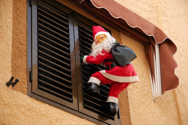 Der Weihnachtsmann klettert einen Fensterladen hinauf Polop Costa Blanca Spanien