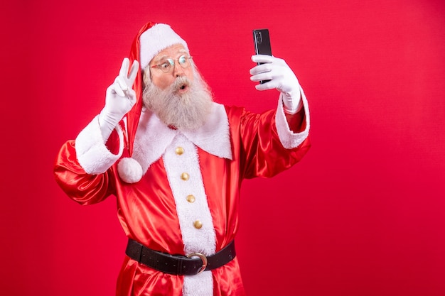 Der Weihnachtsmann macht ein Selfie mit dem Smartphone