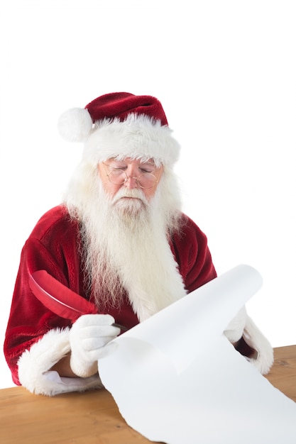 Der Weihnachtsmann schreibt etwas mit einer Feder