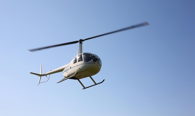 Der weiße kleine Hubschrauber des Flugzeugs macht den Flug in geringer Höhe