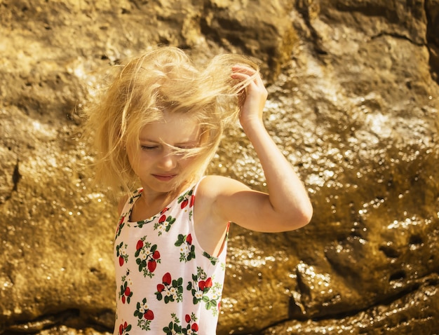 Der Wind spielt die Haare im blonden Mädchen