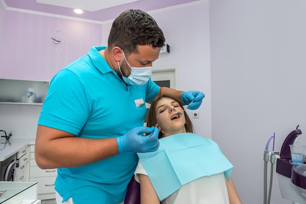 Der Zahnarzt kontrolliert die Zähne eines Patienten, der zur Untersuchung beschädigter Zähne kam