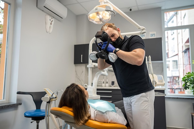 Der Zahnarzt macht Fotos von den Zähnen des Patienten, um die Ergebnisse am Ende der Fotostomatologie zu überprüfen
