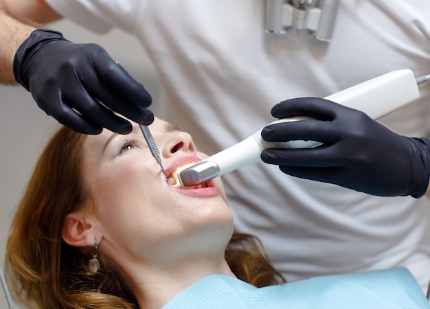 Der Zahnarzt scannt die Zähne des Patienten mit einem 3D-Scanner.