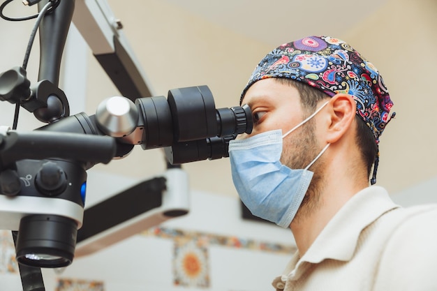 Foto der zahnarzt untersucht den mund des patienten mit einem zahnmikroskop zahnbehandlung das konzept des mikroskops für gesunde zähne in der zahnmedizin