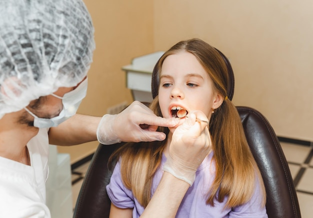Der Zahnarzt untersucht die Zähne des Kindes im Konzept der Zahnmedizin und Zahnmedizin