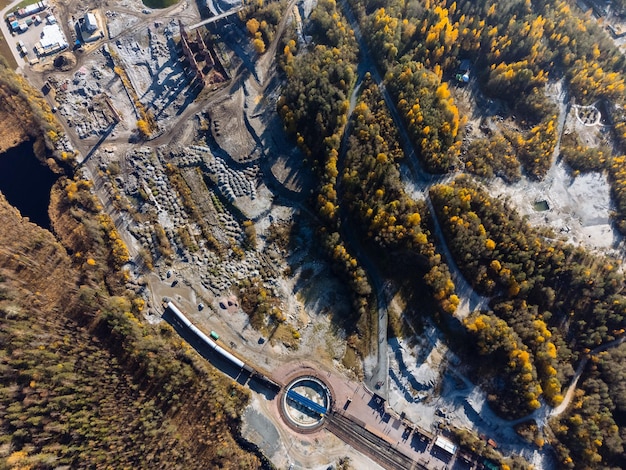 Der Zug ist von einer Herbstwaldseeschlucht und einem Steinbruch von oben umgeben Der Blick auf den Ruskeala-Park von der Drohne