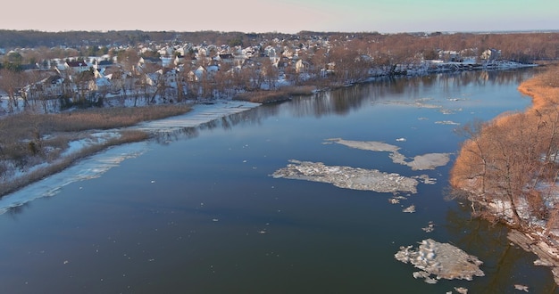 Deriva temprana de primavera en un hermoso río con piezas rotas ver el complejo de los suburbios de la casa desde una altura