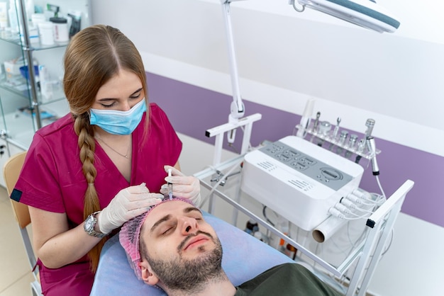 Dermatologista experiente fornece procedimento antienvelhecimento no centro de bem-estar O homem está deitado com os olhos fechados Closeup