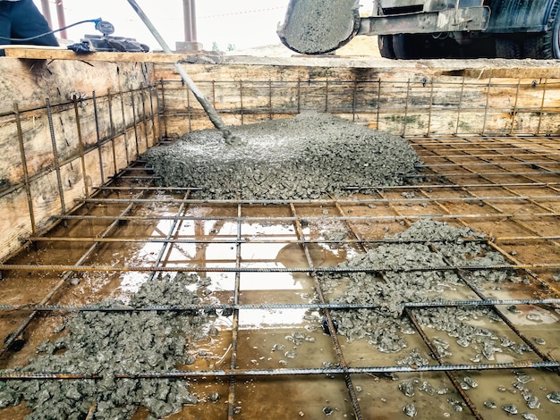 Derramando a fundação com concreto no canteiro de obras Trabalhos monolíticos de concreto armado durante a construção do edifício