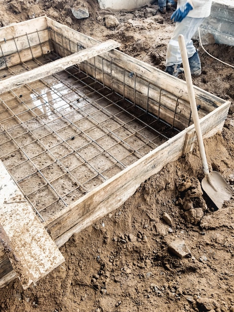 Derramando a fundação com concreto no canteiro de obras Trabalhos monolíticos de concreto armado durante a construção do edifício