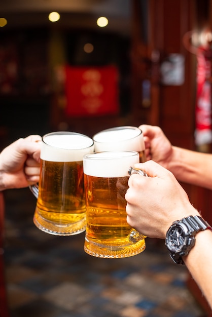 Derramando cerveja em pé no balcão do bar. grande cerveja artesanal sábia na torneira no menu de café ou pub. brindando com amigos no bar