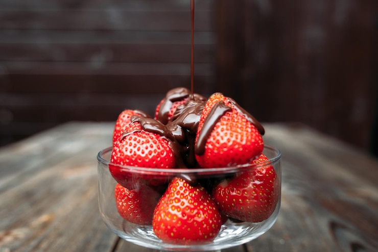 Foto derramando chocolate em morangos na tigela de vidro
