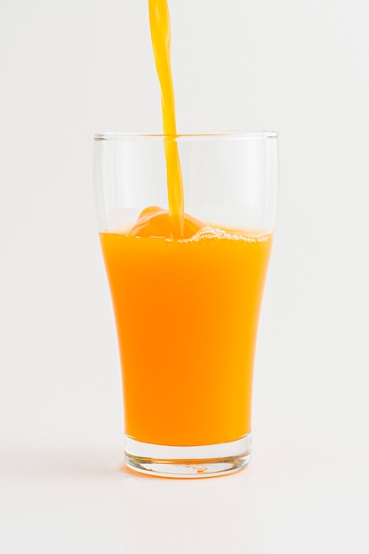 Derramando suco de laranja orgânico fresco em um copo