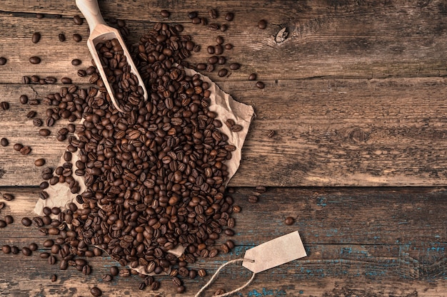 Derramar granos de café de una bolsa de lino y una espátula de madera