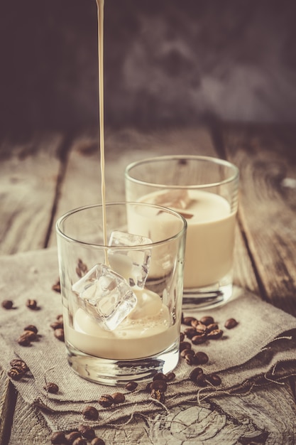 Foto derramar licor de café em copos com gelo e feijão