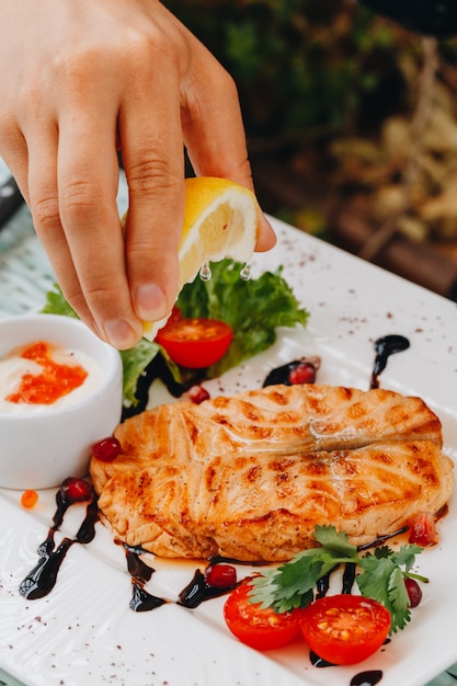 Foto derramar suco de limão em pedaços de salmão