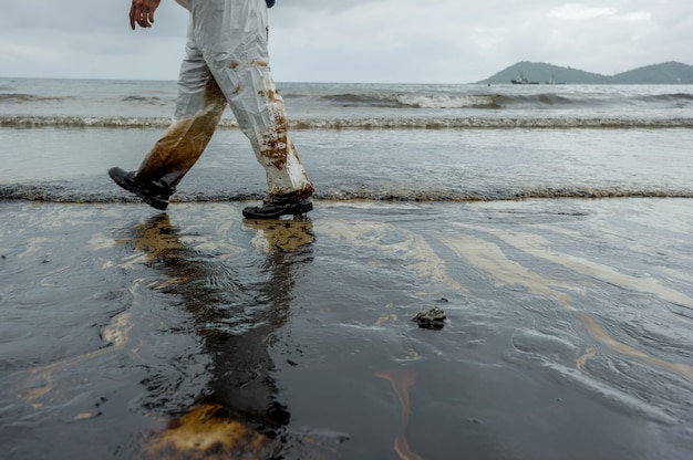 Derrame de petróleo misturado com outras substâncias químicas na superfície do mar e areia.