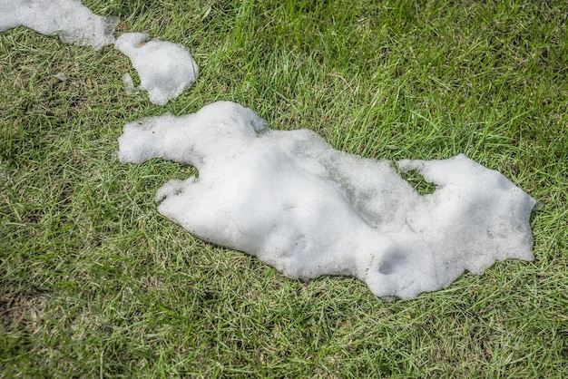 Derretendo a neve na natureza na grama verde