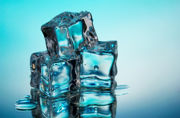 Derretir cubitos de hielo sobre fondo azul.