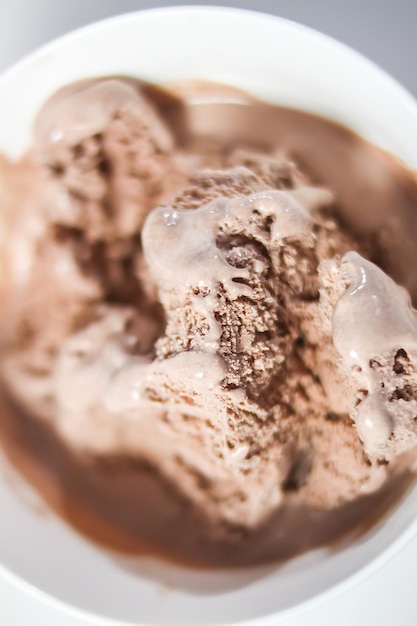 Foto derretir helado de chocolate en una taza de cerámica blanca