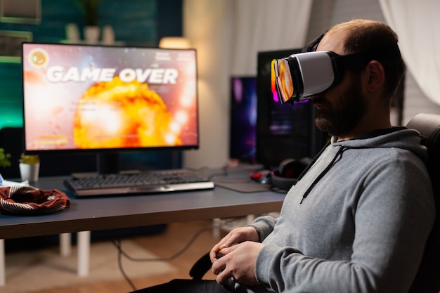 Derrotó a un jugador perdiendo el torneo de videojuegos jugando con un casco de realidad virtual. Jugador competitivo que usa el joystick para la competencia en línea a altas horas de la noche en la sala de juegos