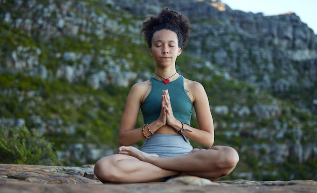 Desacelere e deixe a meditação levá-lo em uma jornada Foto de uma jovem meditando nas montanhas