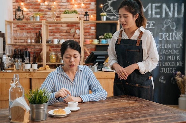 Desacuerdo entre camarera y clienta en una cafetería moderna. mujer cliente quejándose de la calidad y el sabor de las bebidas al personal en el bar restaurante. a la infeliz invitada no le gusta la comida.