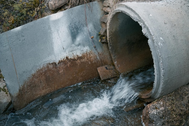 Foto desagüe de esgoto de um tubo para o rio conceito de poluição de rios e ecologia poluição da água esgoto drenagem tubo sujeira drenagem de águas residuais águas residuais ruins da gestão de esgotos da cidade