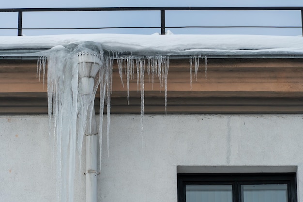 Los desagües están cubiertos de hielo y nieve Después de una fuerte tormenta de nieve la ciudad está cubierta de nieve y hielo Hay muchos carámbanos en la fachada del edificio Hielo en aceras y caminos