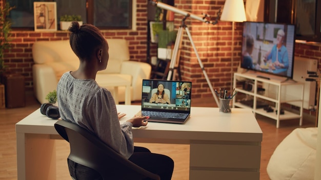Desarrollador discutiendo en videoconferencia sobre nuevas ideas para un proyecto en línea creando una carrera independiente desde la oficina en casa mujer afroamericana usando conexión de reunión en Internet