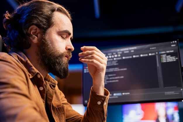 Desarrollador estresado cerrando los ojos para relajarse mientras corrige errores en el software