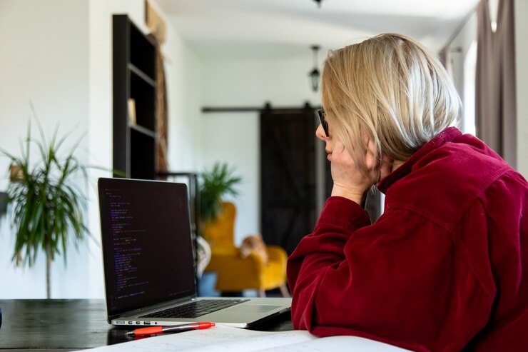 Foto desarrollador de mujer cansada que trabaja con la computadora en la oficina en casa