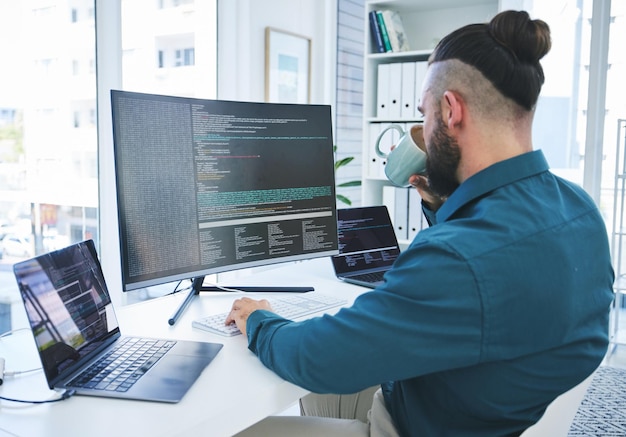 Desarrollador programador o hombre en la computadora para codificar scripts de software o seguridad cibernética en la oficina Detrás de un técnico de TI con café y tecnología para programar el futuro y análisis de datos