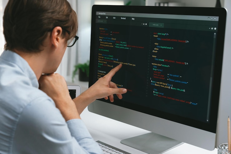 Foto desarrollador que apunta a la codificación de software en la pc comparando el dinero de la computadora portátil