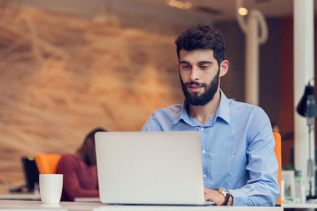 Desarrollador de software empresarial de inicio que trabaja en una computadora en una oficina moderna