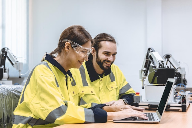 Desarrollador de software del equipo de ingenieros feliz trabajando juntos escribiendo el código fuente del programa para el control de robots