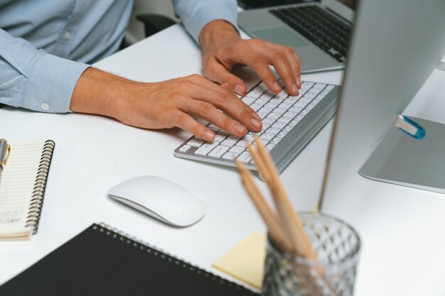 Desarrollador de TI con manos cortadas que trabaja con información de software en línea en la computadora Pecuniary