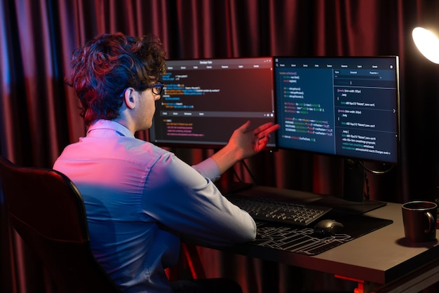 Desarrollador de TI que trabaja concentrando software en línea en la sala de luces de neón Gusher