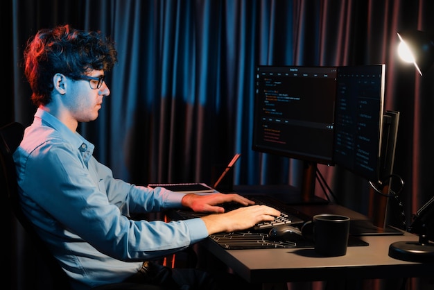 Desarrollador de TI que trabaja concentrando software en línea en la sala de luces de neón Gusher