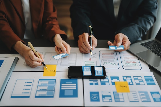 Desarrollador de UX y diseñador de ui tormenta de ideas sobre el diseño de wireframe de la interfaz de la aplicación móvil con el breif del cliente y el código de color en officexA