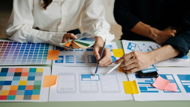 Desarrollador de UX y diseñador de ui tormenta de ideas sobre el diseño de wireframe de la interfaz de la aplicación móvil con el breif del cliente y el código de color en officexA